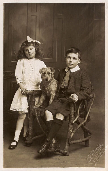 A Brother and Sister posing with their pet dog