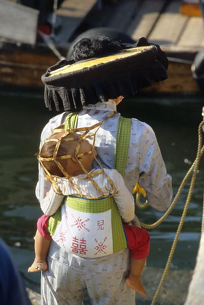 A Hakka woman carrying her infant child in a papoose