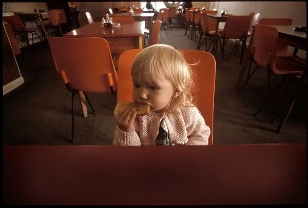 A Little girl eating toast in a cafe