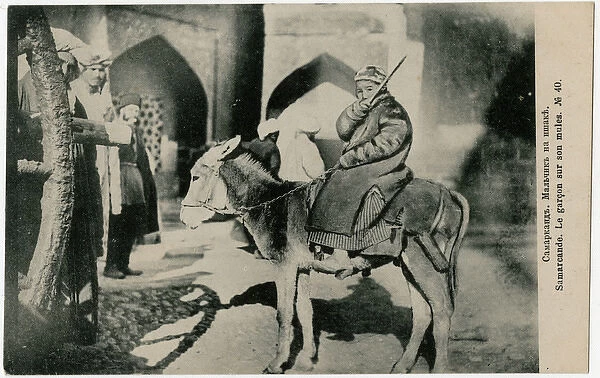 Samarkand, Uzbekistan - A young boy riding his mule