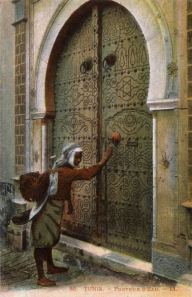 Tunis - Tunisia, water carrier knocking on ornate door