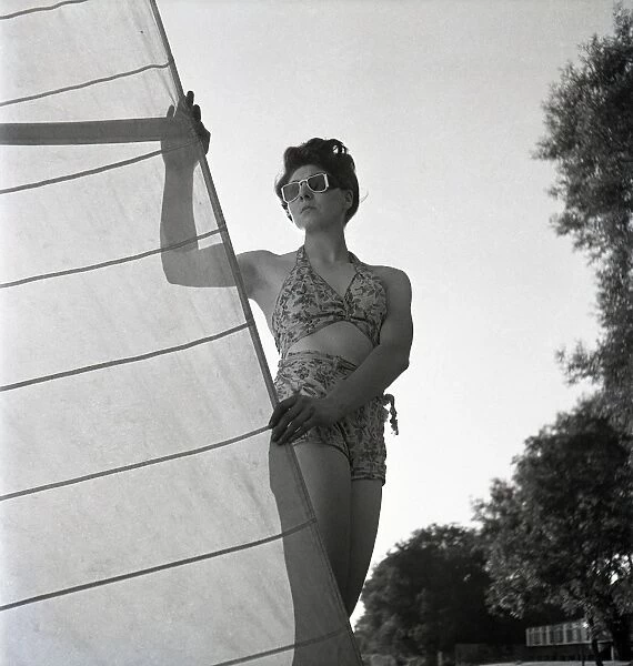Woman on St Ives beach with yacht sail