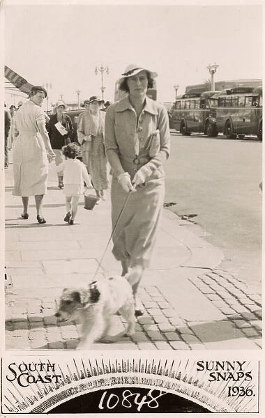 Woman with terrier on a lead at the seaside