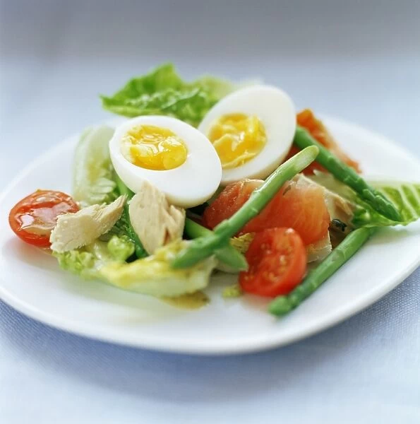 Salad made with boiled egg, asparagus, pink grapefruit, tomato, tuna and lettuce