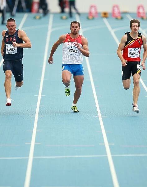 Sprinters. Three athletes seen during a 100 metre sprint race
