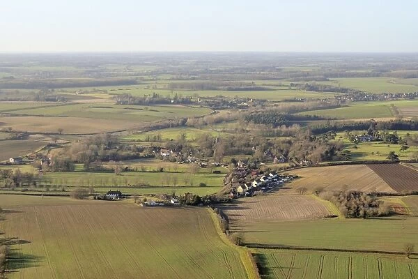 Aerial view of rolling rural landscape with small villages, winter wheat fields and pastureland, Suffolk, England, United Kingdom, Europe