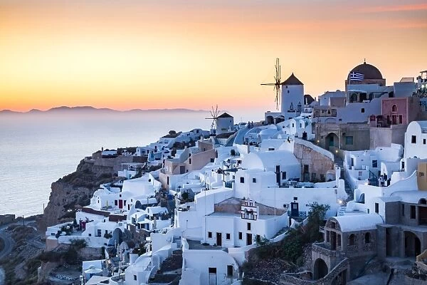 Sunset view over the whitewashed buildings and windmills of Oia from the castle walls