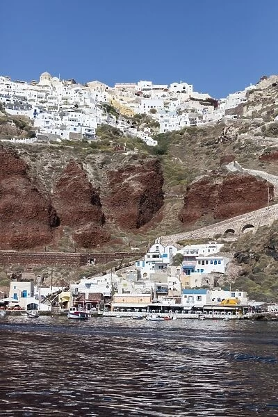 Typical Greek village perched on volcanic rock with white and blue houses and windmills