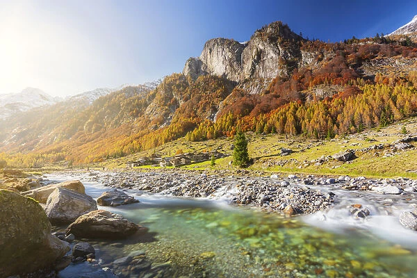 Alpine torrent with view on the alpine village in autumn