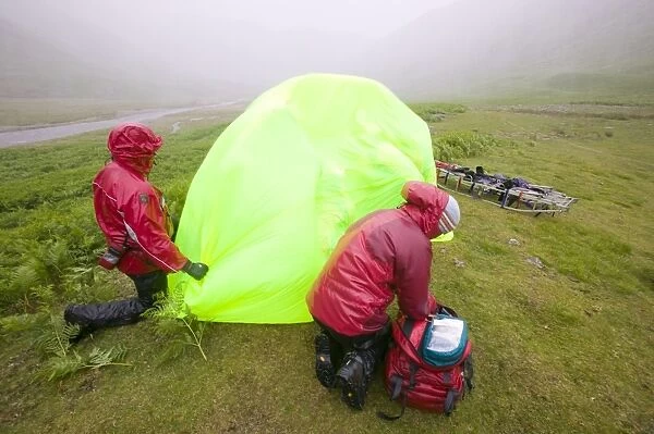 Members of Langdale Ambleside mountain rescue Team treat a collapsed walker suffering from hypothermia protected from the foul weather by a group shelter. Lake