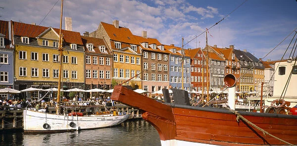 10128095. DENMARK Copenhagen Boats on Nyhavn Canal with pavement cafes