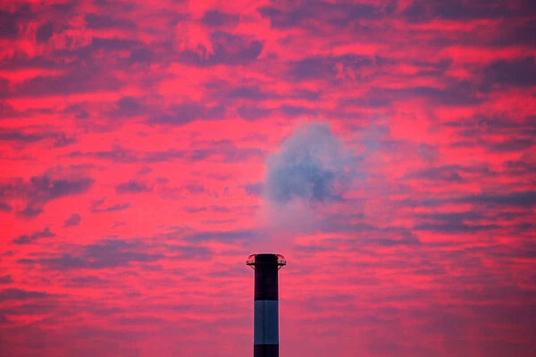 Steam rises from a smoke stack at sunset in Lansing, Michigan