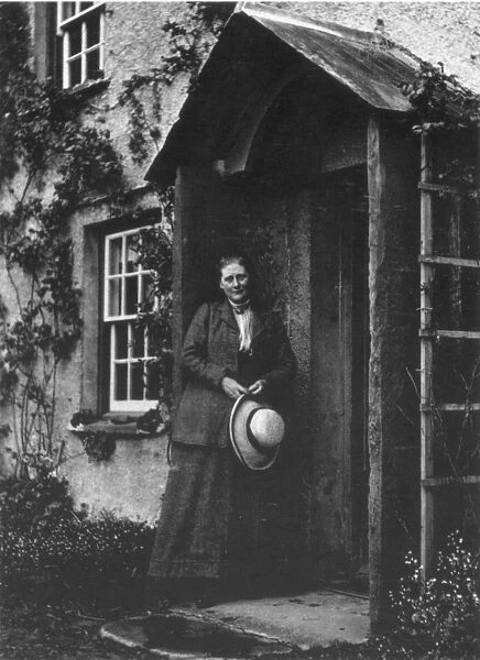 BEATRIX POTTER (1866-1943). English writer. Standing in the doorway of her farm
