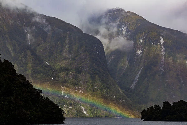 A rainbow and misty weather in Doubtful Sound, Southland in New Zealand