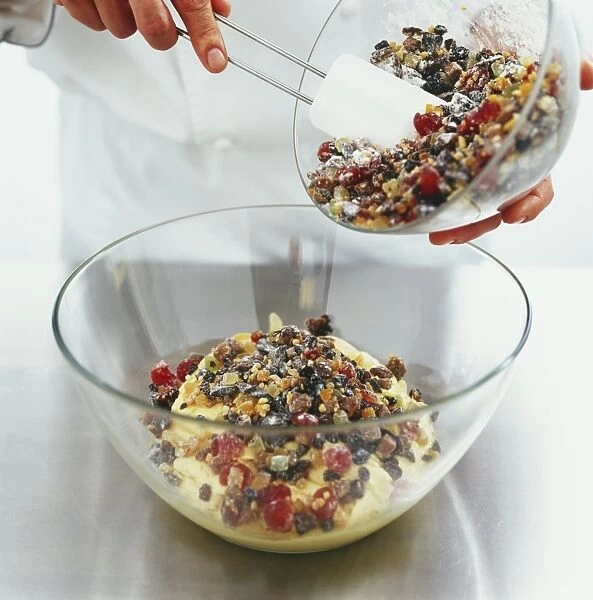 Adding mixture of dried fruit to creamy dough mixture in a bowl