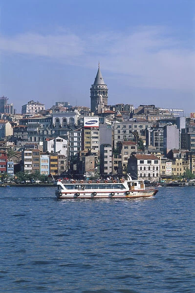 Asia, Turkey, Istanbul, passenger ferry passing the waterfront of Karakoy below the Galata Tower, skyline behind