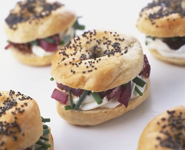 Baby bagels filled with roasted red onion, goats cheese and chives, close up