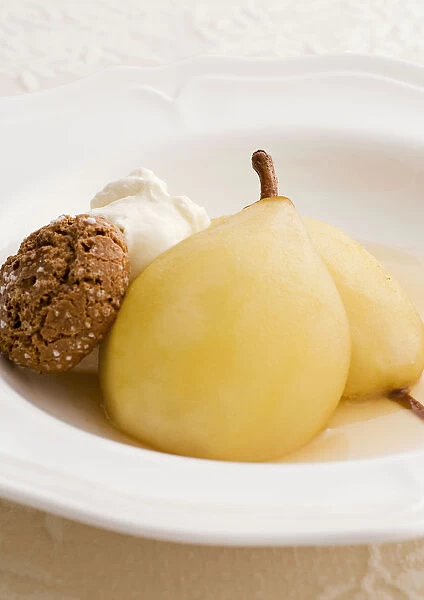 Two baked pears in Marsala with amaretti biscuits and whipped cream, close-up