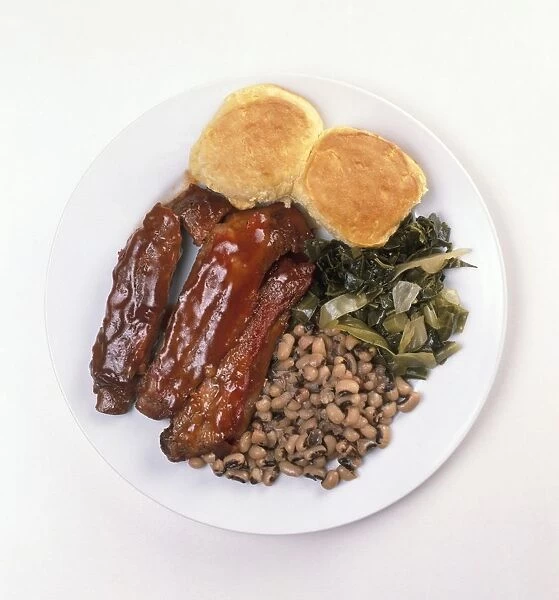 Barbecued pork ribs, corn bread muffins, collard greens, and black-eyed peas, served on a plate