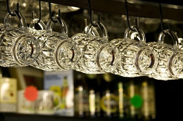 Beer glasses hanging on hooks in traditional pub