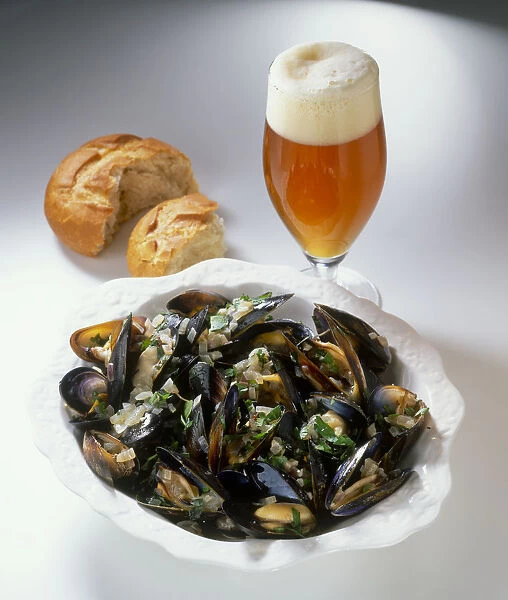 Bowl of mussels cooked in India Pale Ale, glass of India Pale Ale and bread roll