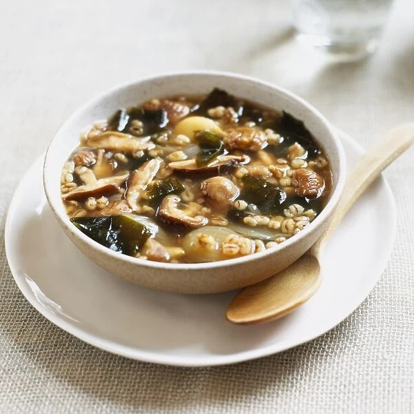 Bowl of soup containing barley, chestnuts, shiitake mushrooms, onions and wakame seaweed