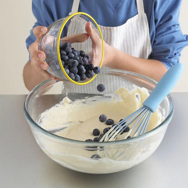 Boys hands adding blueberries to pancake batter