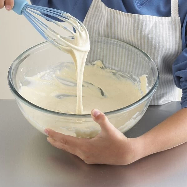Boys hands using a whisk to beat pancake batter in bowl
