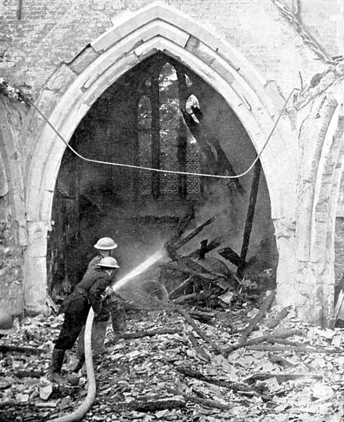 British fire-fighters damping down smouldering roof timbers of a church hit by German bombs