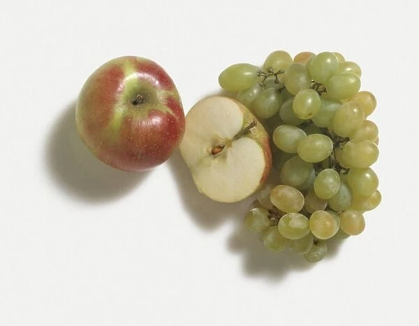 Bunch of white grapes, apple and half apple