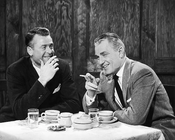 Businessmen smoking cigarettes and smiling
