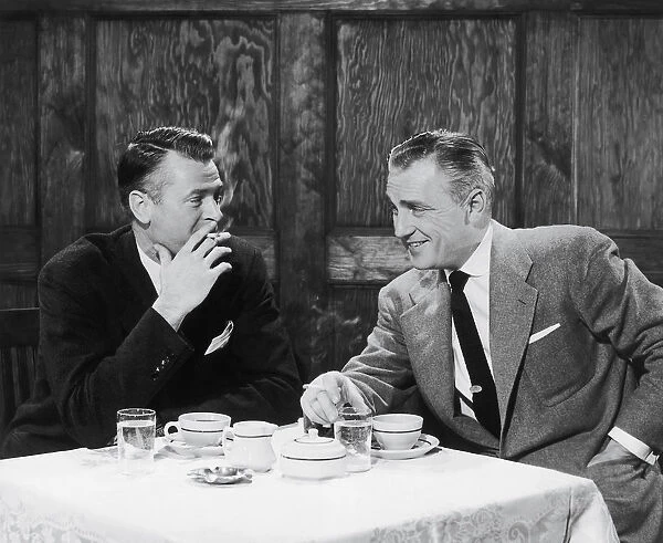 Businessmen smoking cigarettes and smiling