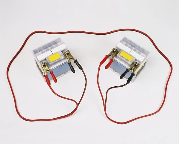 Two car batteries attached by jump leads