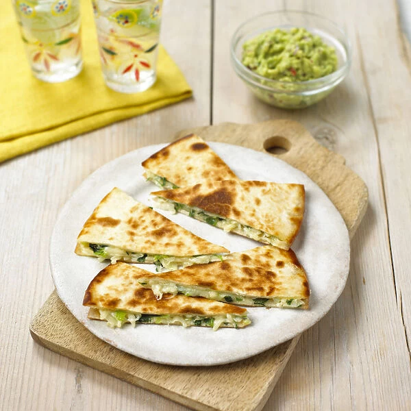 Cheese quesadillas stuffed with spring onions, served with avocado salsa