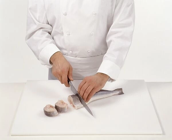 Chef preparing a round fish and cutting it into steaks