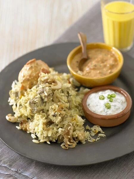 Chicken Biryani served with dips on a plate, and a glass of lassi nearby