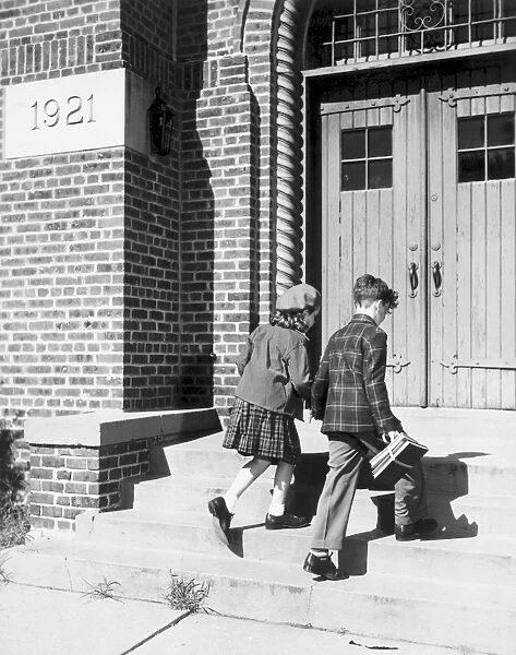 Two children walking into school