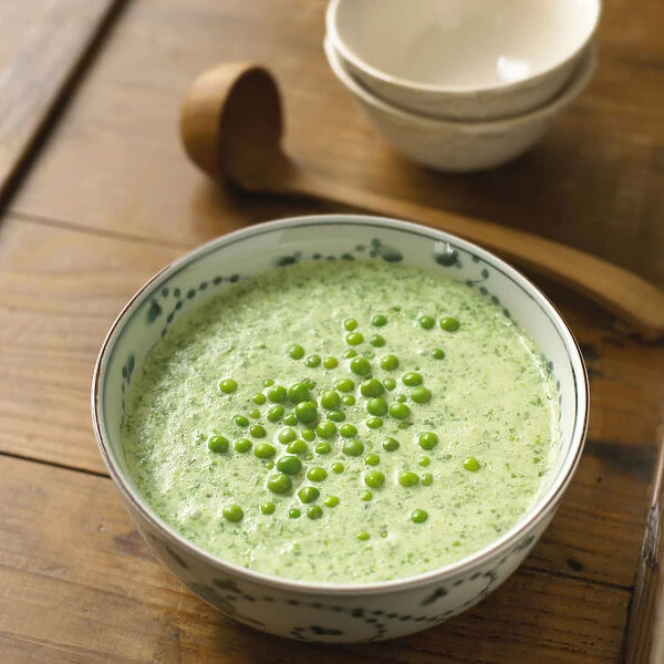 Chilled lettuce soup in a bowl with peas on top