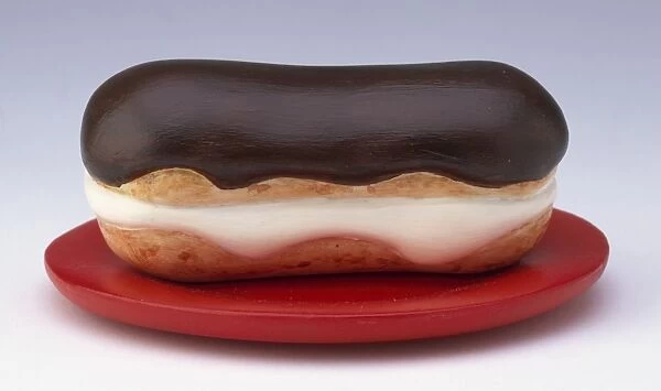 Chocolate eclair made out of plastic on a red plate