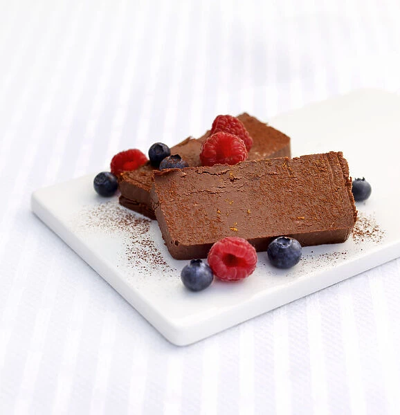 Chocolate parfait with blueberries and raspberries on chopping board