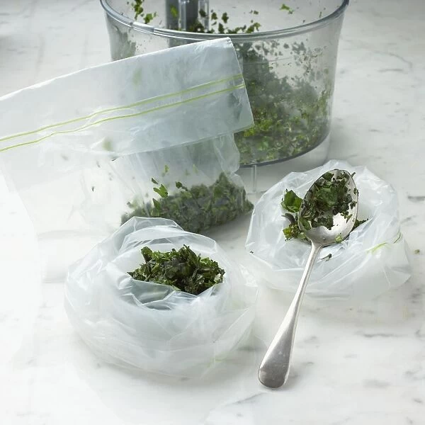 Chopped herbs in freezer bags and mixing bowl on marble surface