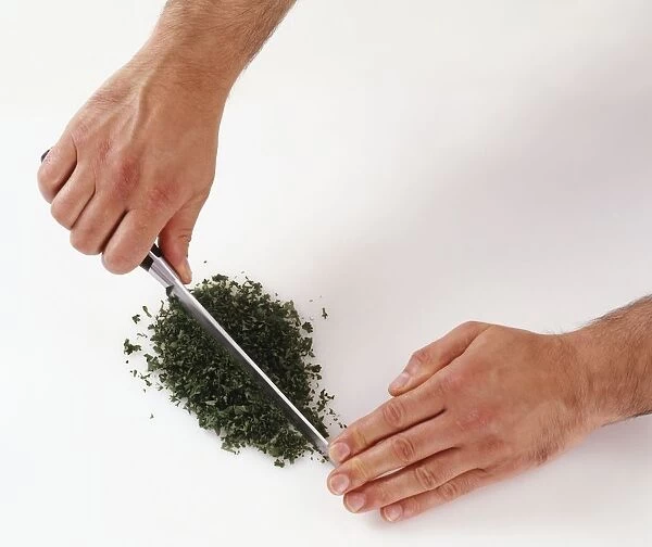 Chopping parsley with a knife, close-up