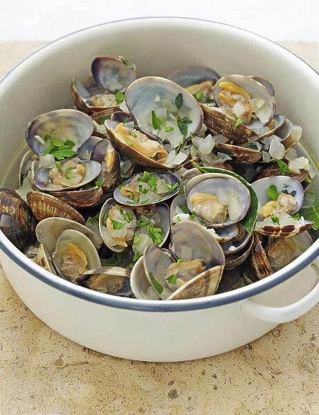 Clams in white wine sauce in pan, close-up