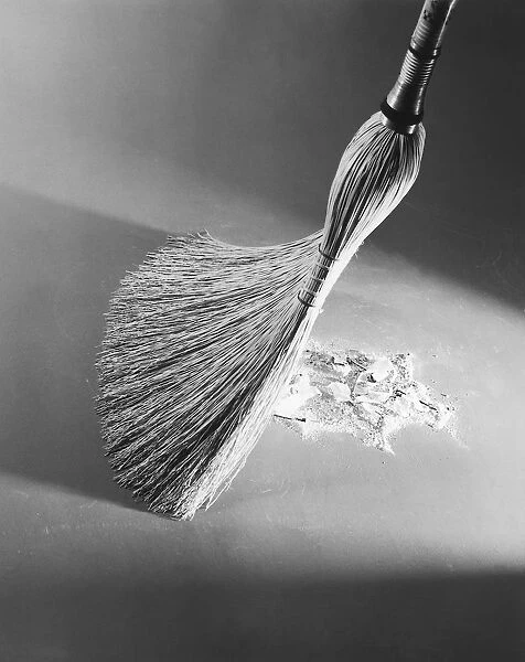 Close-up of a broom sweeping up dirt