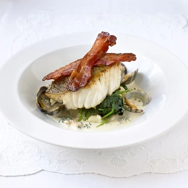 Cod and clams served in white bowl with bacon and cream sauce