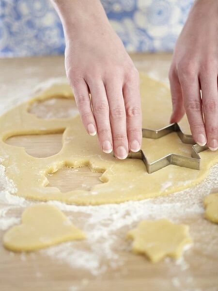 Cookie cutter cutting pastry shapes, close-up