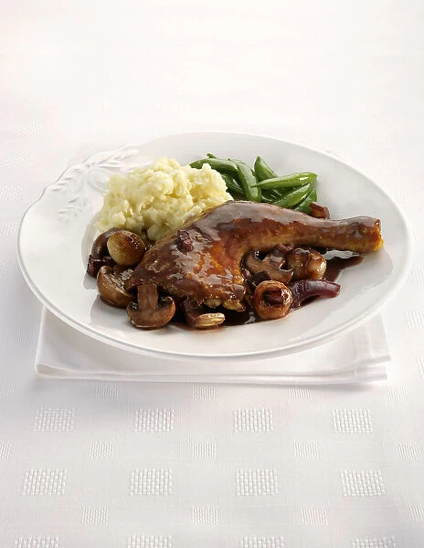 Coq Au Vin on plate with vegetables, close-up