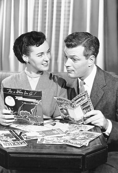 Couple with brochures deciding on vacation