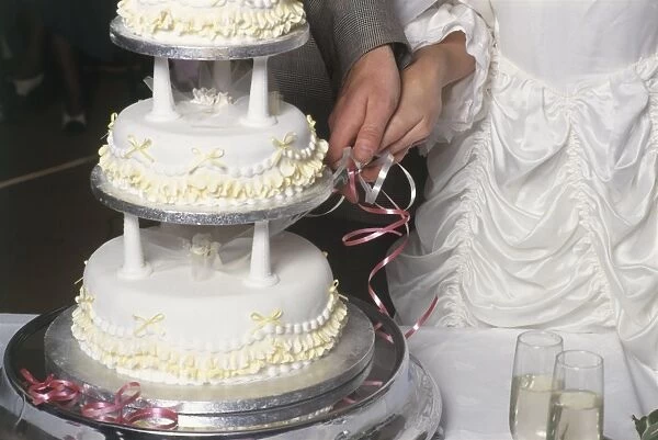 Couple cutting wedding cake, close-up