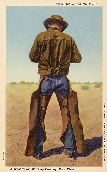 Cowboy Wearing Chaps. ca. 1934, Texas, USA, Time Out to Roll His Own A West Texas Working Cowboy, Rear View. No moving picture acting in his life-just hard work on the range as vividly proven by his wide and powerful shoulders, bow legs, and saddle-worn chaps